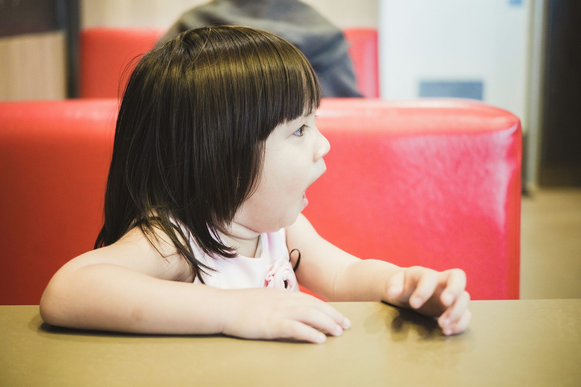 girl sitting on red leather sofa